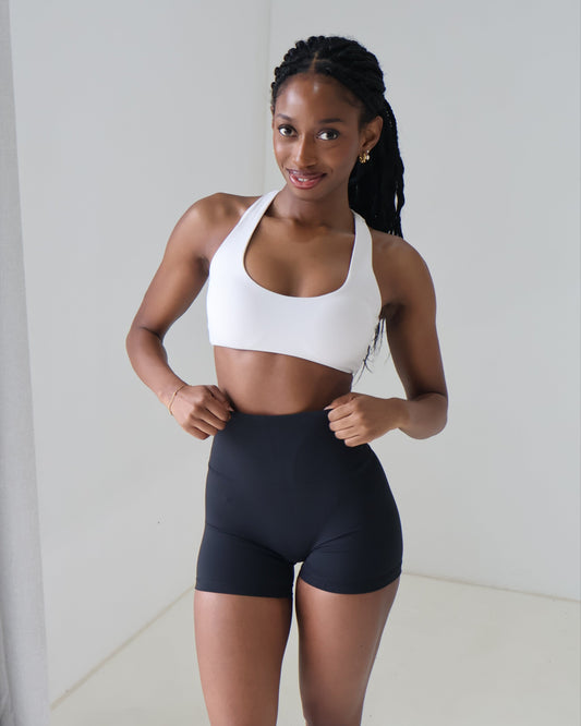 White cream sports bra racer back scoop neck paired with black bike shorts