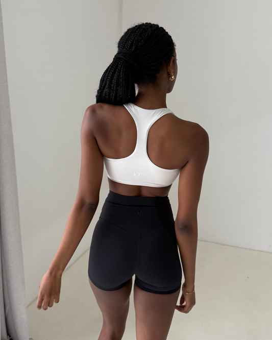 Womens activewear back shot with racer back detailing and minimal logo branding paired with shorts