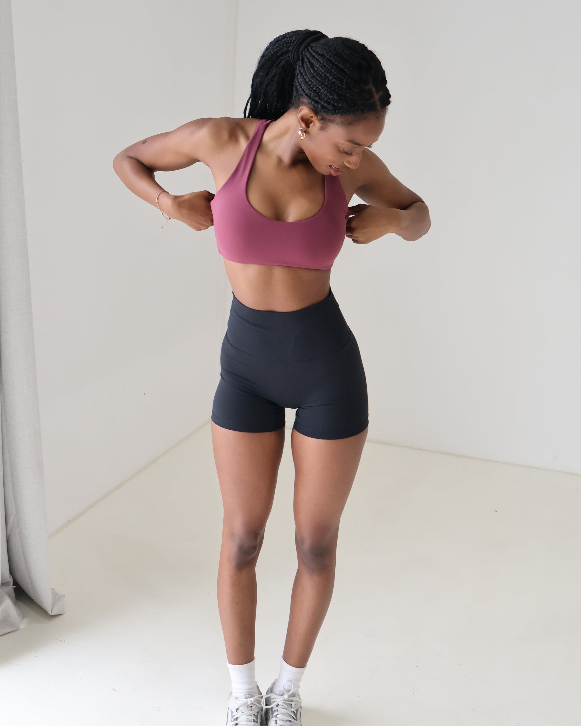 Model showing black biker shorts paired with dusty rose crop top sports bra